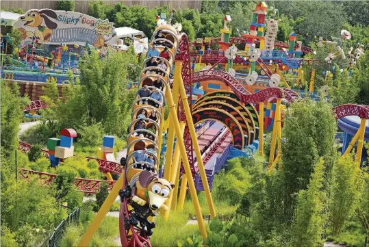  ?? PHOTO BY MATT STROSHANE ?? Slinky Dog Dash:Slinky’s coils twist and turn around the curves, hills and drops of the Slinky Dog Dash at Toy Story Land at Disney’s Hollywood Studios. The coaster is Disney’s first with a double-launch. Walt Disney World Resort guests get to race and dive around a track that stretches across Toy Story Land.