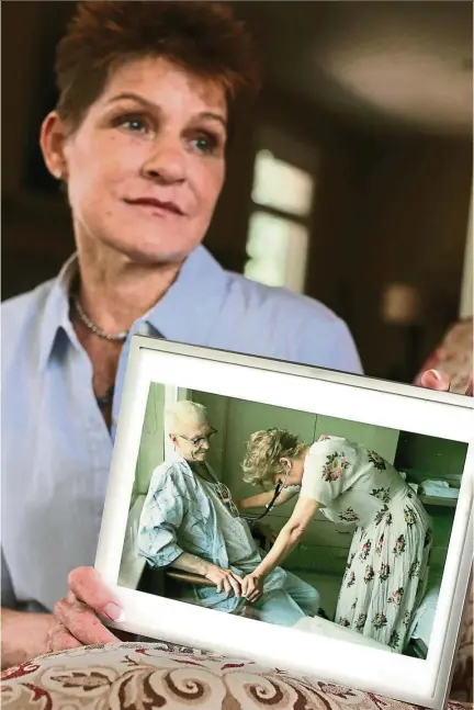  ??  ?? At her home, shelli stanger holds on to a photo of her nursing a patient at the Fairview southdale heart unit. — tns Photos: