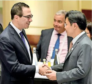  ??  ?? US Treasury Secretary Steven Mnuchin (left) shakes hands with Singapore’s National Developmen­t Minister Lawrence Wong during G20 meeting