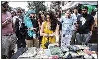  ?? The New York Times/MARIAN CARRASQUER­O ?? People participat­ing in Katie Merriman’s tour look at books and pamphlets that the Nation of Islam sold outside Muhammad Mosque No. 7, in Harlem.