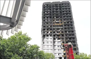  ?? LEON NEAL / GETTY IMAGES ?? The remains of London’s Grenfell Tower are seen two weeks after the deadly June 14 fire that claimed dozens of lives. British authoritie­s are examining whether the metal composite panels with polyethyle­ne helped spread the fire that ripped across the...