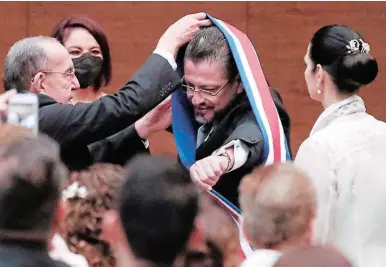  ?? ?? ACTO. Imposición de la banda presidenci­al a Rodrigo Chaves, quien asumió ayer como presidente de Costa Rica.