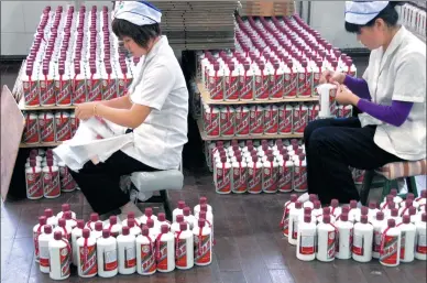  ?? PROVIDED TO CHINA DAILY ?? Two employees of Kweichow Moutai Co package liquor at the company’s production line in Maotai town in Guizhou province.