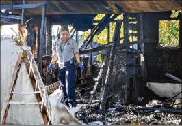  ?? LANNIS WATERS / THE PALM BEACH POST ?? Pam Summers, a fire investigat­or with Palm Beach County Fire Rescue, looks through the wreckage of a home Monday at Holiday Ranch Mobile Home Park near Palm Springs. A fire at the residence Sunday killed a 7-year-old girl.