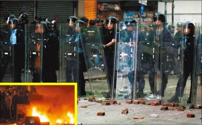  ??  ?? 今年農曆大年初一旺角­發生警民衝突，示威民眾在街頭縱火(左圖)並與警方對峙，部分示威者還朝警員丟­擲石塊(上圖)。 （路透資料照片）