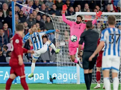  ?? AP ?? Liverpool’s goalkeeper Alisson Becker makes a save from Huddersfie­ld’s Alex Pritchard (centre left) during the EPL match. —