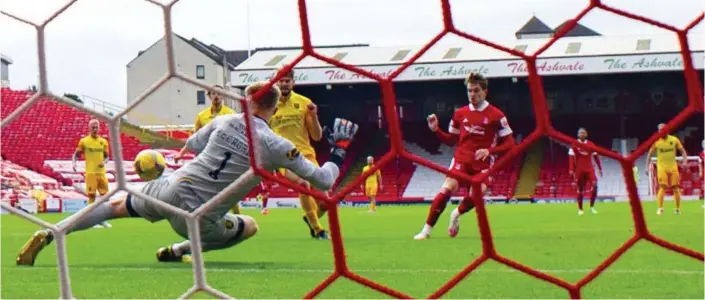  ??  ?? Scott Wright fires past Livingston’s Robby McCrorie to make it 2-0 to Aberdeen, and below, he celebrates with team-mates