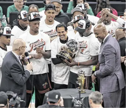  ?? WINSLOW TOWNSON USA TODAY Sports ?? Heat center Bam Adebayo holds the trophy as head coach Erik Spoelstra, center, and forward Jimmy Butler help celebrate after their upset victory over the Celtics in Game 7 of the Eastern Conference Finals at TD Garden on May 29, 2023.