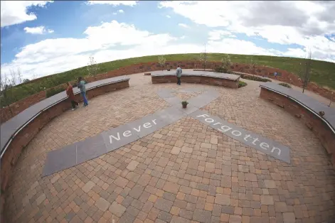  ?? DAVID ZALUBOWSKI/ASSOCIATED PRESS ?? IN THIS PHOTO TAKEN WITH A FISHEYE LENS, people visit the Columbine Memorial on April 17 in Littleton, Colo. The 12 students and a teacher killed in the Columbine High School shooting will be remembered on Friday in a vigil on the eve of the 25th anniversar­y of the tragedy.