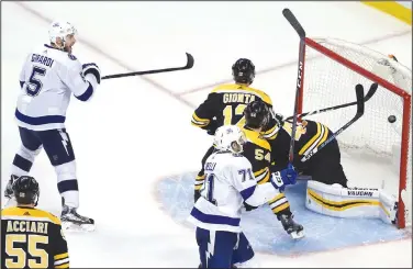  ?? AP/ELISE AMENDOLA ?? Tampa Bay’s Dan Girardi (5) scores the game-winning goal against Boston Bruins goaltender Tuukka Rask in overtime Friday night in Boston. The Lightning won 4-3 and now lead the series 3-1 over the Bruins.