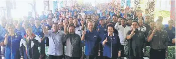  ??  ?? Penguang (front, fifth left) and others showing the sign for unity during a photo-call during the programme at SMK Tinjar.