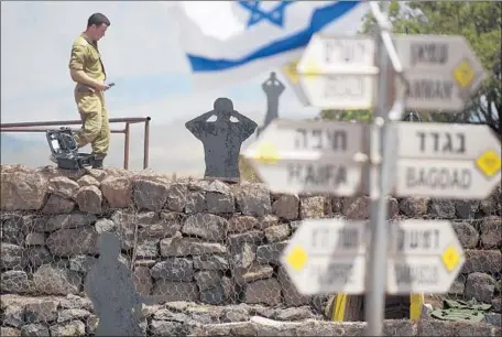  ?? Lior Mizrahi Getty Images ?? AN ISRAELI soldier stands guard at a post in the Golan Heights, where Israel said Iran fired 20 rockets on Thursday. In response, Israel hit Iranian targets in neighborin­g Syria in the largest Israeli air force strike since the Yom Kippur War of 1973.