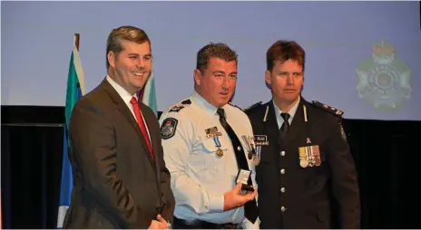  ?? Photos: Tara Miko ?? HONOURS: At the Combined QPS and QFES Medals and Awards Ceremony are (from left) Police Minister Mark Ryan, Sergeant Trevour O'Neil and Superinten­dent Mark Kelly.