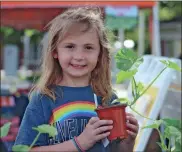  ?? Jeremy stewart ?? Kat Luke holds up the plant she picked out at the Rockmart Farmers Market to take home with her at the season-opening market in downtown Rockmart on Thursday, May 4.