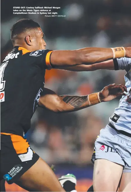  ?? Picture: BRETT COSTELLO ?? STAND OUT: Cowboy halfback Michael Morgan takes on the Wests Tigers defence at Campbellto­wn Stadium in Sydney last night.