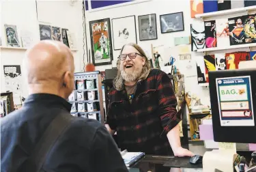  ?? Photos by Michael Short / Special to The Chronicle ?? Brian Hibbs, who has kept Comix Experience in San Francisco open for 30 years, chats with a customer.