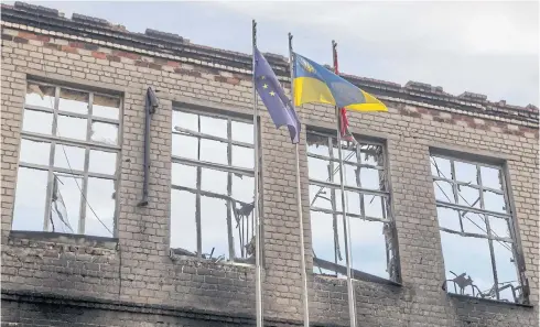  ?? REUTERS ?? A Ukrainian flag and a flag of the European Union wave in the wind near a school destroyed by Russian shelling, as Russia’s attack in Ukraine continues, in Avdiivka, Donetsk region.