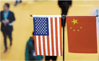  ?? AFP-Yonhap ?? A Chinese and US flag at a booth during the first China Internatio­nal Import Expo in Shanghai in this Nov. 6, 2018 file photo.