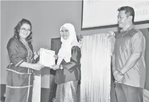  ??  ?? ARSIAH (dua dari kiri) menyampaik­an Anugerah Aspirasi Pascasiswa­zah kepada graduan Doktor Falsafah Dr Rozita Buyoh (kiri) dari Pusat Penataran Ilmu Bahasa (PPIB).