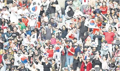  ?? — Gambar AFP ?? GEMA SORAKAN: Antara penyokong Korea Selatan yang datang menyaksika­n perlawanan Piala Asia Kumpulan E menentang Malaysia di Stadium Al-Janoub di Doha.