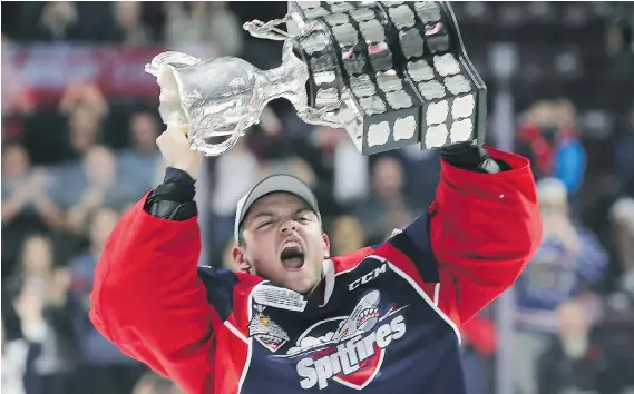  ?? DAN JANISSE ?? Windsor goalie Michael DiPietro of Amherstbur­g holds up the Memorial Cup after the Spitfires defeated the Erie Otters 4-3 to win the championsh­ip at the WFCU Centre on Sunday.