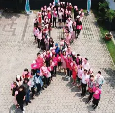  ??  ?? Guests form the shape of pink ribbon during the launch.