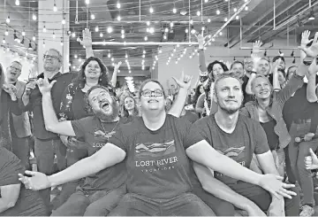  ??  ?? Deaf entreprene­urs Andrew St. Cyr, Jane Jonas, and Shawn Harrington co-owners of Lost River Vacations, participat­e in a group photo during a fundraiser at Red Bear Brewing Company in Washington. — Photos for The Washington Post by Evelyn Hockstein