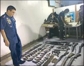  ?? ROMINA CABRERA ?? Quezon City police chief Senior Superinten­dent Guillermo Eleazar examines firearms seized from the Triple A Guns and Ammo Store during yesterday’s raid.