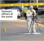  ??  ?? Forensics officers at the scene