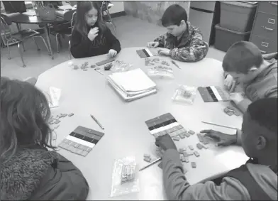  ??  ?? Tiles: Junction City Elementary fourth graders Kandice Rudd, Mason Snider, Kaine Lee and Dakorey Larry explore with fraction tiles to make equivalent fractions in Alicia Risinger’s class.