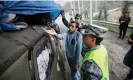  ?? Aziz Karimov/AP ?? An ethnic Armenian resident of Nagorno-Karabakh shows his belongings to an Azerbaijan­i border guard at the Lachin checkpoint on the way to Armenia. Photograph: