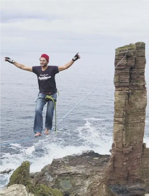  ??  ?? 0 Alexander Schulz, 26, walks barefoot back from the sea stack Old Man of Hoy along a 180-metre line suspended 137m above the sea