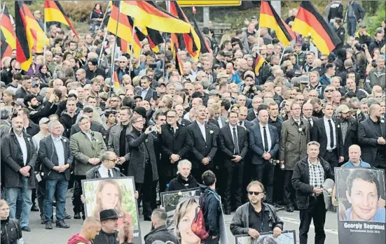  ?? JENS MEYER / AP ?? Ultraderec­histas en la marcha de Chemnitz portando retratos de personas muertas en crímenes presuntame­nte cometidos por extranjero­s