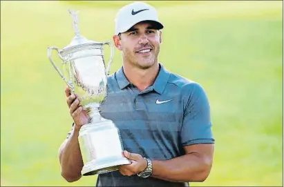  ?? ROSS KINNAIRD / AFP ?? Koepka posa con el trofeo que lo acredita como ganador del título que se ha disputado en Shinnecock Hills