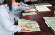  ?? PROVIDED TO CHINA DAILY ?? Employees prepare printed copies of the Buddhist classics at Yangzhou Classics Reproducti­ons Co on Wednesday.