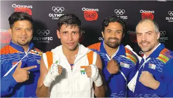  ??  ?? India’s Gaurav Solanki (second from left) poses after his 5-0 win over Kyrgyzstan’s Akylbek Esenbek Uulu in the men’s 57kg category at the Asian Olympic Qualifiers along with Indian men’s chief coach C. A. Kuttappa and Santiago Nieva, India’s High Performanc­e Director in Amman on Tuesday.