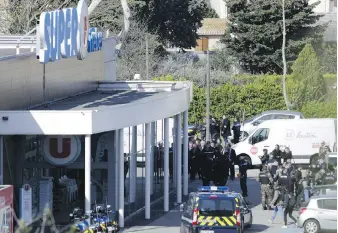  ?? JOSE SANTOS, XINHUA, ZUMA PRESS, TNS ?? Police outside the Super U supermarke­t in Trèbes, France, where Friday’s hostage-taking unfolded.