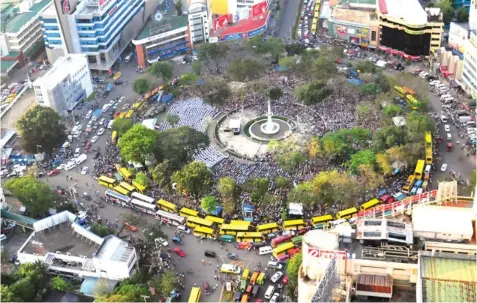  ?? REYNAN VILLENA ?? A huge Iglesia ni Cristo crowd fills Fuente Osmeña during the group’s Grand Bible Exposition in key cities nationwide. The yellow Ceres buses and other vehicles ringing the circle were used to ferry the participan­ts. Photo was taken from the 40th floor...