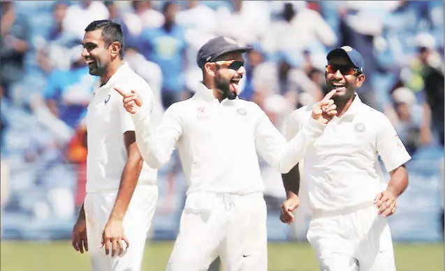  ?? Reuters ?? Kohli, Ashwin and Jayant Yadav celebrate Steve Smith’s dismissal on Day One of the first Test in Pune. Australia were 256 for nine at stumps, with Matt Renshaw and Mitchell Starc scoring fifties.