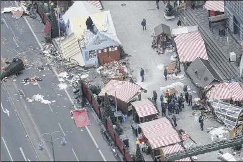  ?? MARKUS SCHREIBER / AP ?? German Chancellor Angela Merkel and other government members visit the site of the attack in Berlin, Germany, Tuesday.