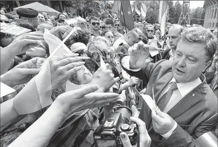  ?? ASSOCIATED PRESS ?? MYKOLA LAZARENKO Petro Poroshenko, a Ukrainian presidenti­al candidate, is greeted by his supporters during a rally in central Ukraine. Voters will cast presidenti­al ballots next Sunday.