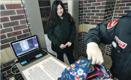  ?? CARLOS OSORIO/THE ASSOCIATED PRESS ?? Alondra Alvarez, a student at Western Internatio­nal High School in Detroit, goes through a metal detector and has her backpack checked as she enters the school. Security measures in many urban schools have made them tough targets for mass shootings.