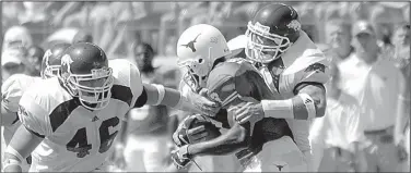  ?? Arkansas Democrat-Gazette file photo ?? Arkansas linebacker Caleb Miller (right) tackles Texas running back Selvin Young (3) while Miller’s teammate Clarke Moore closes in during their game against the Longhorns. The Razorbacks’ defense held Texas to 326 yards of offense and forced three...