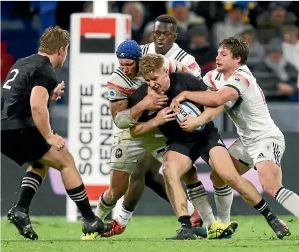  ?? PHOTO: REUTERS ?? All Blacks centre Jack Goodhue is wrapped up by several French XV tacklers during the match in Lyon yesterday.