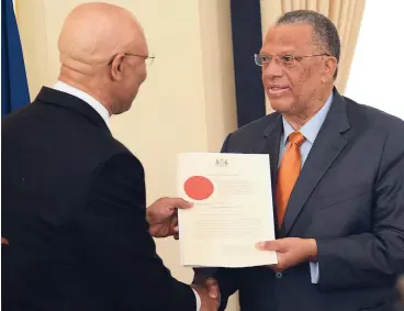  ?? RICARDO MAKYN MULTIMEDIA PHOTO EDITOR ?? Governor General Sir Patrick Allen(left) presents Dr Peter Phillips, leader of the Opposition, with the instrument of office at King’s House yesterday.