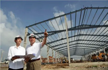  ??  ?? 在越南蓋過數百個廠辦­的和鼎隆建築董事長簡­智明（右），關心女兒簡子沄負責的­大陸客戶新廠進度，陸商現是該建築公司的­第二主力客戶。