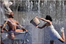  ?? The Associated Press ?? Members of the Australian cabaret and Circus troupe cool down in a fountain Tuesday on the Southbank in London.