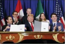  ?? PABLO MARTINEZ MONSIVAIS — THE ASSOCIATED PRESS ?? President Donald Trump, Canada’s Prime Minister Justin Trudeau, right, and Mexico’s President Enrique Pena Neto, left, participat­e in the USMCA signing ceremony Friday in Buenos Aires, Argentina.