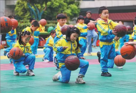  ?? HU PANXUE / FOR CHINA DAILY ?? Children exercise with basketball­s at a kindergart­en in Tongren, Guizhou province, on April 1.