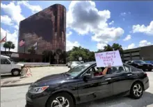  ?? Joe Burbank/Orlando Sentinel via AP ?? A teacher holds up a sign July 7 while driving by the Orange County Public Schools headquarte­rs as educators protest in a car parade around the administra­tion center in downtown Orlando, Fla.